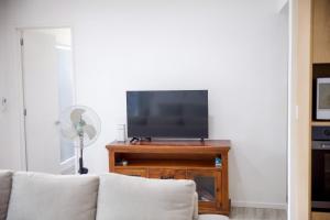 a living room with a couch and a flat screen tv at Taisia & Liku Homes in Nuku‘alofa +3 photos