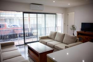 a living room with a couch and a tv at Taisia & Liku Homes in Nuku‘alofa