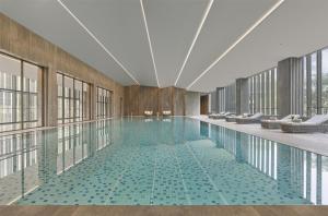a swimming pool in a building with windows at Hyatt Regency Shanghai Pudong Lingang in Zhenghai