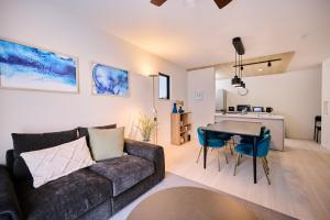 a living room with a couch and a table at White Breeze House in Ginowan