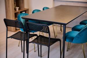 a table and chairs with blue chairs around it at White Breeze House in Ginowan