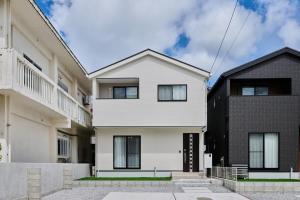 a white house with a black at White Breeze House in Ginowan