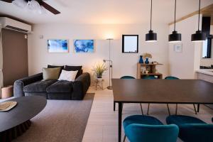 a living room with a couch and a table at White Breeze House in Ginowan