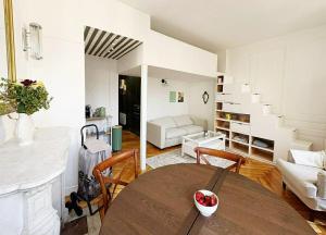 a living room with a table and a room with a staircase at Peaceful haven in Honfleur +12 photos