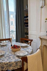 a dining room table with a bowl of fruit on it at Peaceful haven in Honfleur