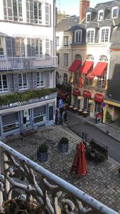 a city street with buildings and tables and umbrellas at Peaceful haven in Honfleur