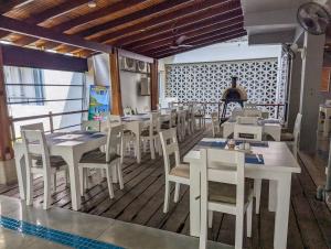 a restaurant with white tables and chairs in a room at Oceanfront condo 3-2-01- Nilaveli in Nilaveli
