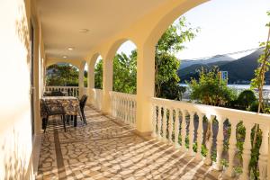 a house with a balcony with a table and chairs at Stevovic Apartments - Brand New Apartments in Tivat