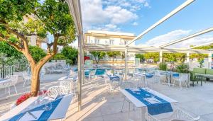 a patio with tables and chairs and a pool at Villa Massa Residence in Sant'Agnello