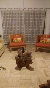 sala de estar con 2 sillas y mesa de centro en Mayan Vidanta Villas GOLF a 800 mt de la playa, en Acapulco