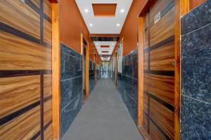 a hallway with wooden doors and tile walls at Hotel O Chikkabanavara Lakeview Bangalore Formerly Bvk Residency in Bangalore