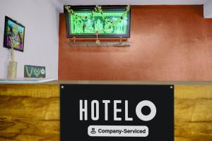 a hotel sign on a wall with a television on it at Hotel O Chikkabanavara Lakeview Bangalore Formerly Bvk Residency in Bangalore