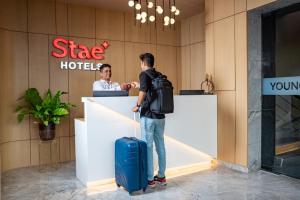 a man with a suitcase standing at a hotel counter at Stae Hotel-Hitec City in Hyderabad