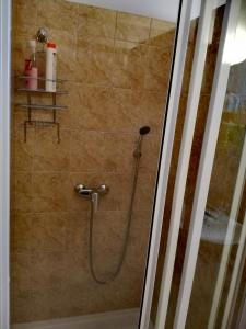 a shower with a hose in a bathroom at Apartmán č. 8 Skalka in Donovaly