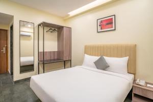 a bedroom with a large white bed and a mirror at Stae Hotel-Hitec City in Hyderabad +14 photos