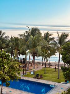 a view of the beach with palm trees and a swimming pool at Oceanfront condo 3-2-01- Nilaveli in Nilaveli