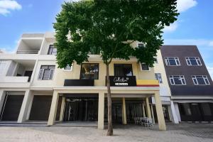 a building with a tree in front of it at Collection O Kharar Bus Terminal Formerly Hotel Kamboj in Kharar