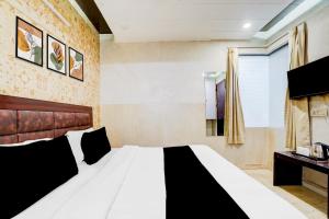 a bedroom with a black and white bed and a window at Collection O Kalka Ji Formerly Hotel Gera in New Delhi +30 photos