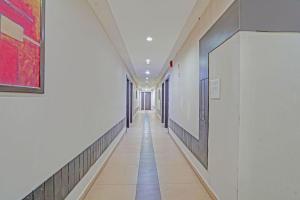 a corridor in a building with white walls and tile floors at Collection O Dhanbad Railway Station Formerly Hotel VIP Residency in Dhanbād +25 photos