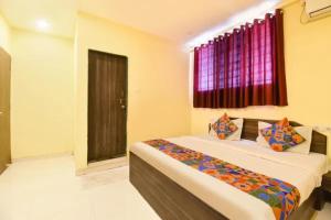 a bedroom with two beds and a window at FabHotel Blue Inn I in Vagholi +27 photos