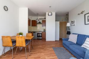 a living room with a blue couch and a table at Apartament Piastowska Elite in Gdańsk