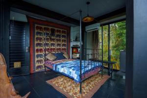 a bedroom with a bed and a large window at Kandyan Mist Retreat in Kandy