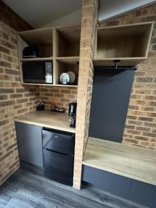 a kitchen with a brick wall and a counter at Clock Tower Motor Inn in Coonabarabran