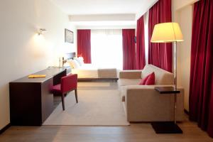 um quarto de hotel com uma cama, uma secretária e um sofá em Hotel Sao Pedro em Arouca
