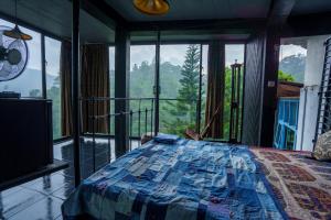 a bedroom with a bed with a view of the mountains at Kandyan Mist Retreat in Kandy +10 photos