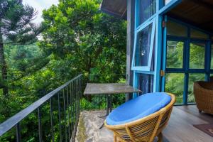 a porch with a chair and a table on a balcony at Kandyan Mist Retreat in Kandy