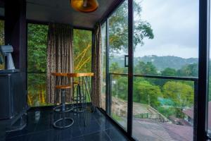 a room with a large window with a chair in front of it at Kandyan Mist Retreat in Kandy