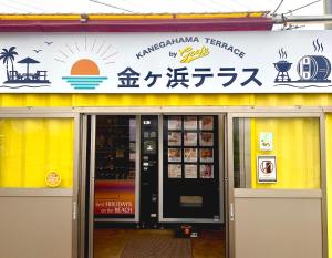 an entrance to a restaurant with a sign on the building at Guest House Goofy in Hyuga