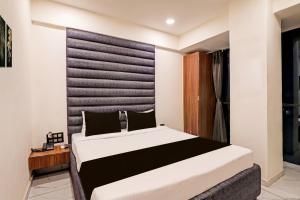 a bedroom with a large bed in a room at Hotel O Althan Formerly Hotel Niraant in Surat +43 photos