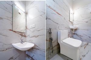 a bathroom with a sink and a toilet and a mirror at Super Collection O Technopark Phase 1 Formerly Snehalayam in Trivandrum