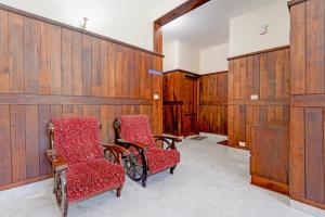 a room with two chairs and wooden walls at Super Collection O Technopark Phase 1 Formerly Snehalayam in Trivandrum