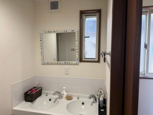 a bathroom with a sink and a mirror at Guest House Goofy in Hyuga +20 photos
