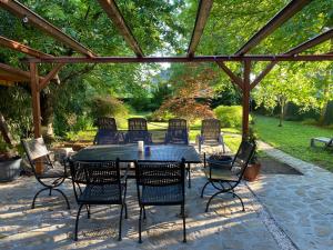 a patio with a table and chairs under a pergola at Páfrányház in Fertőd