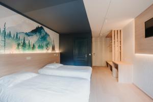 ein Schlafzimmer mit zwei Betten und einem Gemälde an der Wand in der Unterkunft Hotel Saint-Hubert in Malmedy