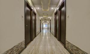 a corridor of a building with black doors and wooden floors at FabHotel CSFC in Bhopal
