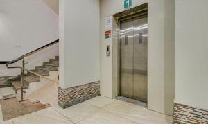 a metal elevator in a building with stairs at FabHotel CSFC in Bhopal