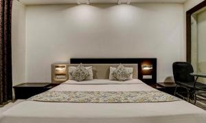 a bedroom with a large white bed with two pillows at FabHotel CSFC in Bhopal +30 photos