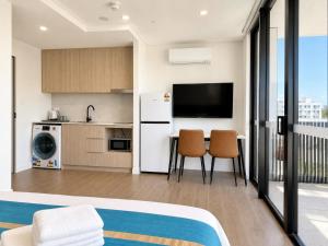 a hotel room with a kitchen and a living room at Granville Studio Ensuite toilet and kitchen in Clyde +5 photos