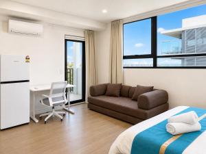 a bedroom with a bed and a couch and a desk at Granville Studio Ensuite toilet and kitchen in Clyde