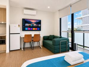 a living room with a green couch and a table at Granville Studio Ensuite toilet and kitchen in Clyde