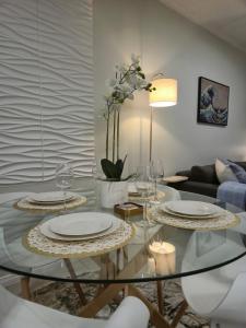 a living room with a glass table with plates and wine glasses at The One Wave - 2 Bed Serenity meets Luxury in Midrand