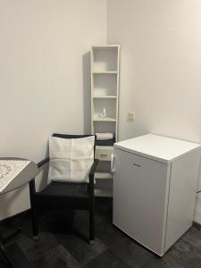 a small room with a chair and a refrigerator at Double Room Stegersbach in Stegersbach