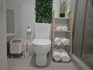 a bathroom with a toilet with plants and towels at The One Wave - 2 Bed Serenity meets Luxury in Midrand +34 photos