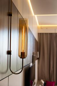 a light hanging on a wall in a room at Central one new apartments - panoramic skyline & boulevard in Tashkent +19 photos