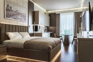 a bedroom with a bed and a kitchen and a table at Central one new apartments - panoramic skyline & boulevard in Tashkent