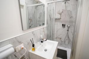 a white bathroom with a sink and a shower at Luxury Apartment Da Giovanni in Caserta +12 photos